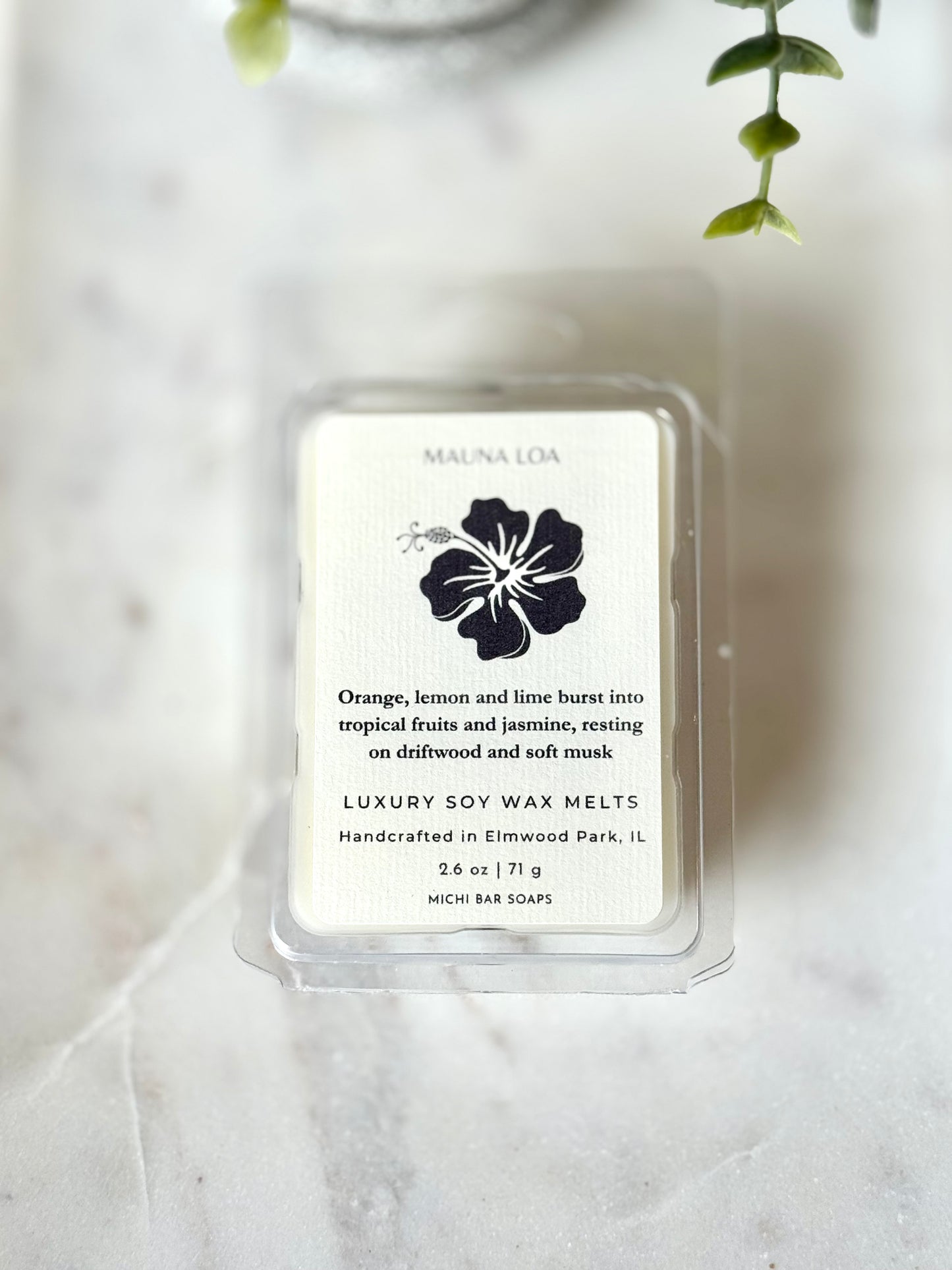 Pack of luxury soy wax melts with a floral design on a marble surface