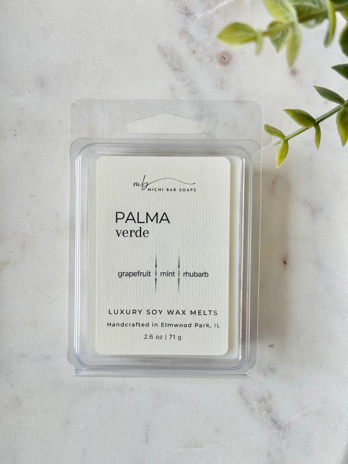Pack of luxury soy wax melts labeled 'Palma Verde' on a marble surface with a plant in the background.