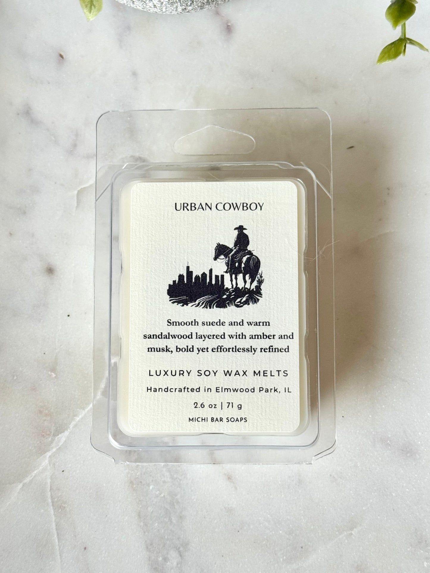 Urban Cowboy wax melt packaging on a marble surface