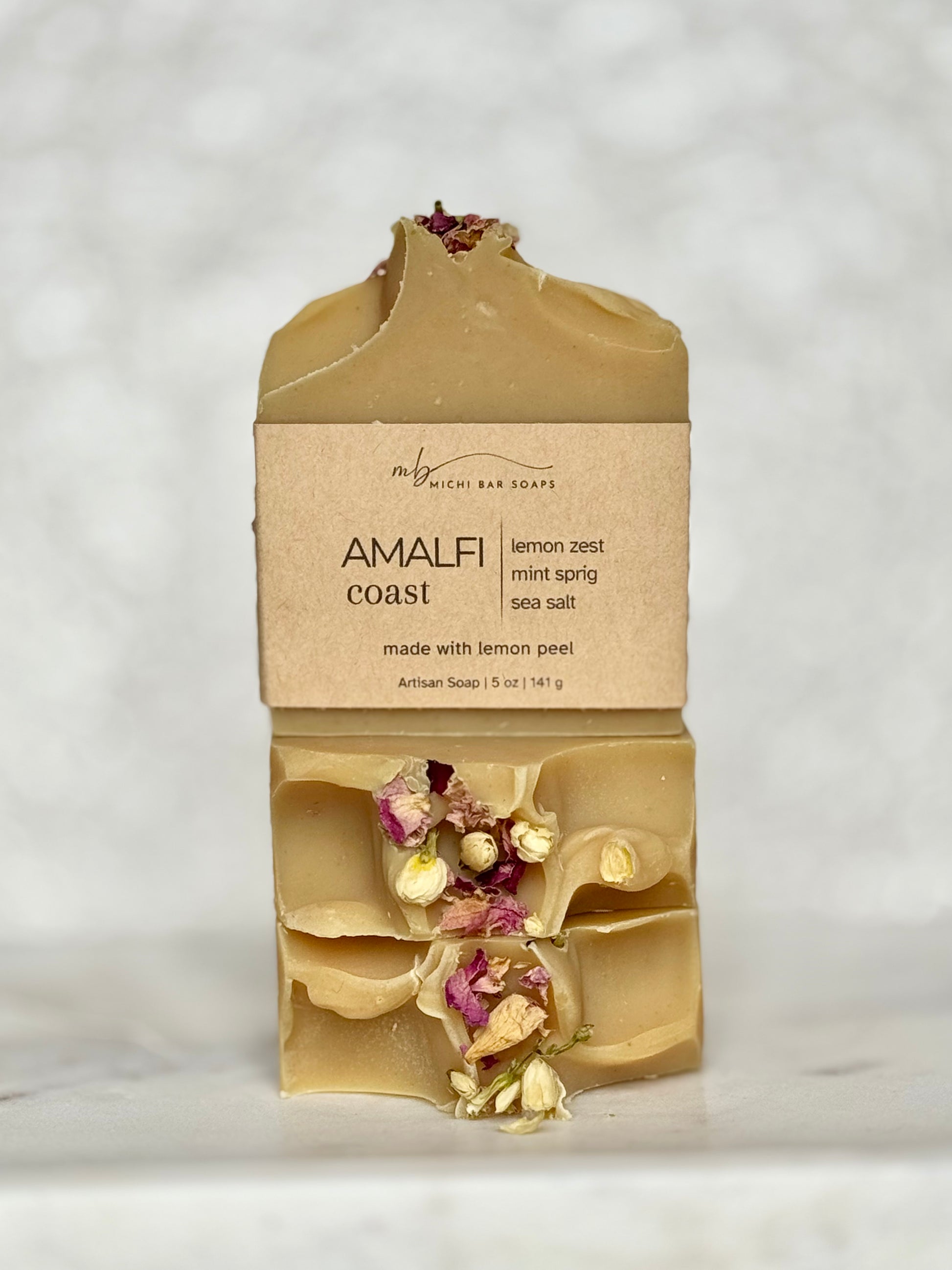 Bar of soap with natural elements and packaging on a light gray background