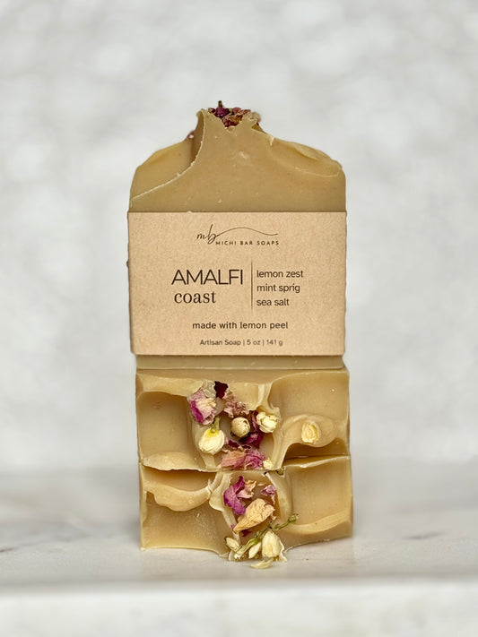 Bar of soap with natural elements and packaging on a light gray background