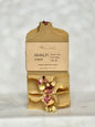 Bar of soap with natural elements and packaging on a light gray background