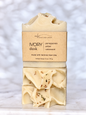 A single bar of handmade soap labeled 'Ivory dusk' by Michi Bar Soaps, wrapped in a kraft paper band and displayed on a light marble surface against a soft marble background.