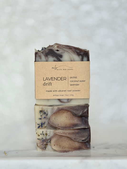 Three stacked soap bars with a label on a textured white background