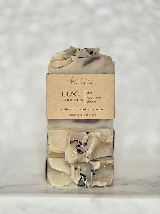 Two bars of soap with a 'Lilac Raindrops' label on a textured white background