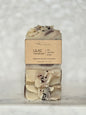 Two bars of soap with a 'Lilac Raindrops' label on a textured white background