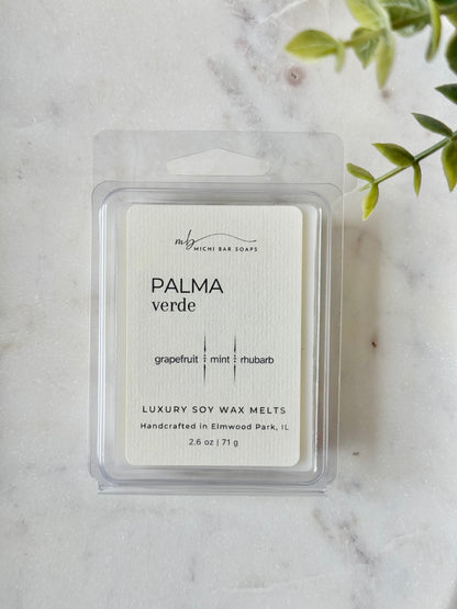 Pack of luxury soy wax melts labeled 'Palma Verde' on a marble surface with a plant in the background.