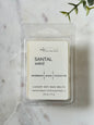 Pack of 'Santal Soleil' soy wax melts on a marble surface with a plant leaf.