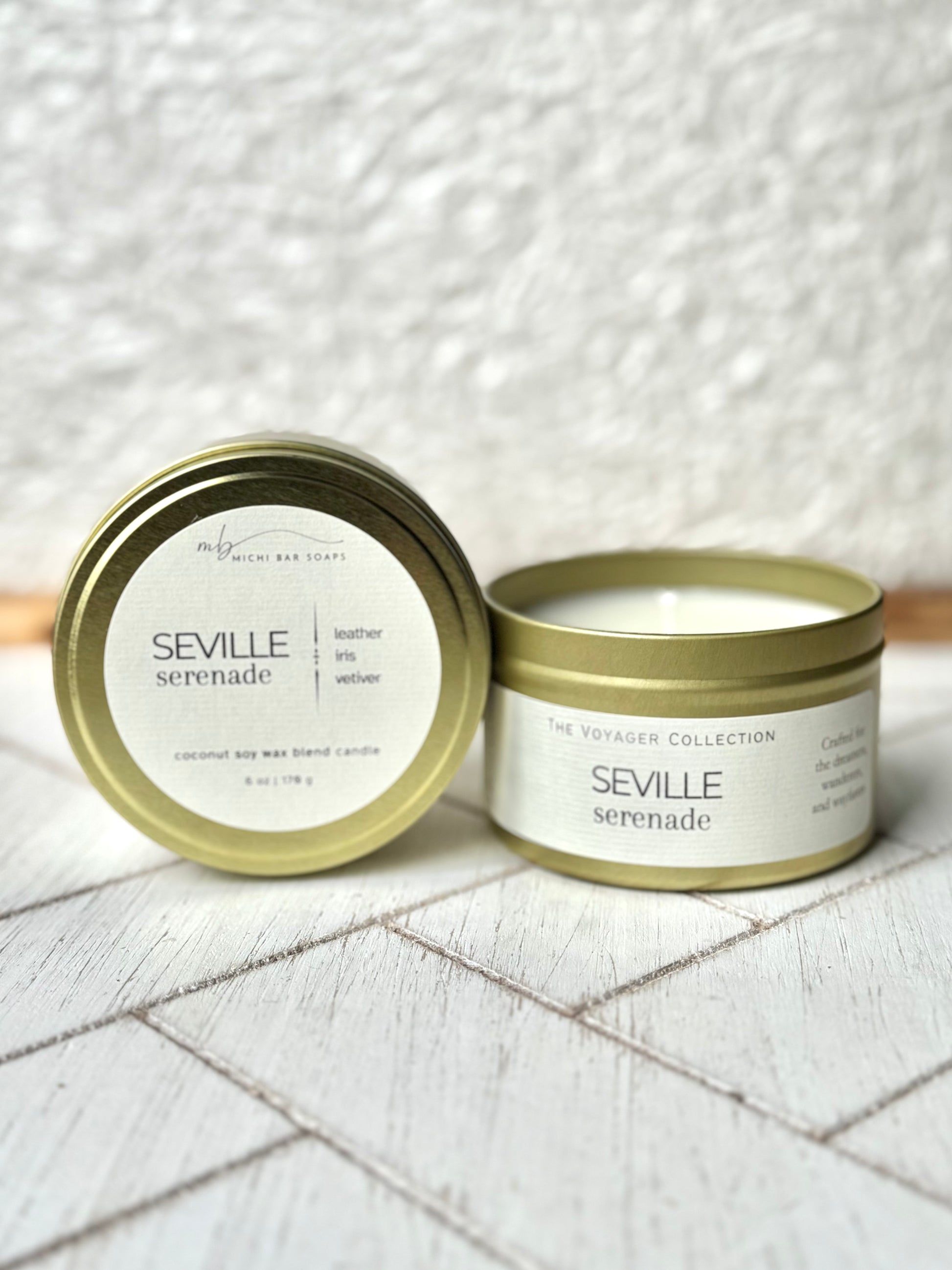 gold tin candles on a wood surface with cream labels