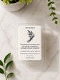 A clear plastic clamshell package containing a single wax melt labeled 'Spa Retreat' by Michi Bar Soaps, placed on a light marble surface with green leaves and a small plant in the background.