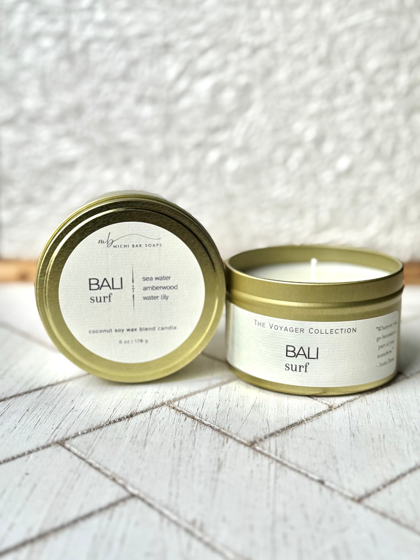 gold tin candles with cream labels that say Bali Surf with scent notes of sea water, amberwood, water lily