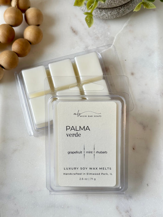 Pack of luxury soy wax melts labeled 'Palma Verde' on a marble surface with decorative elements.