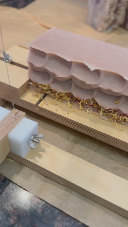 patchouli & sandalwood artisan soap loaf being cut into bars